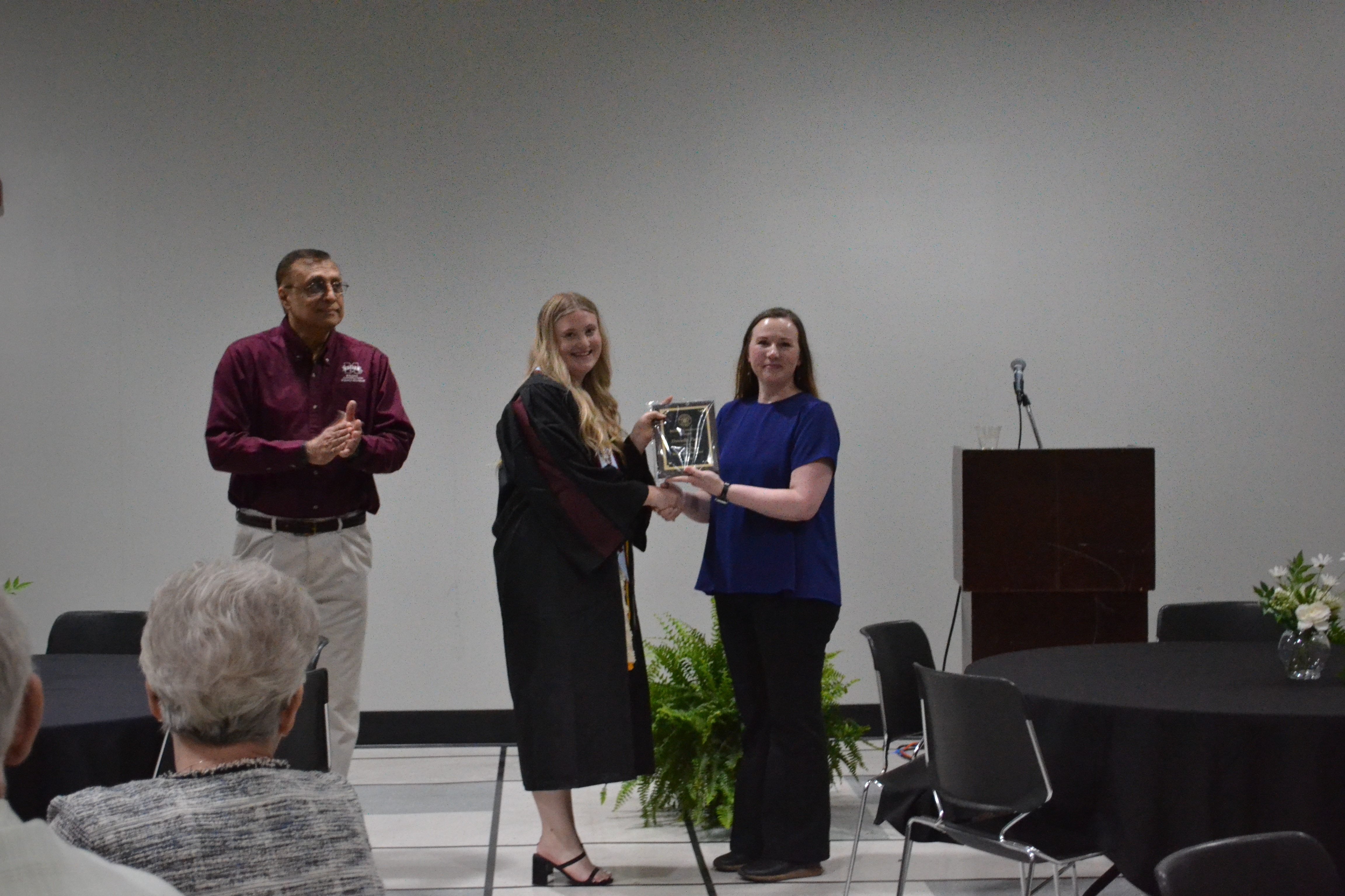 Associate Professor Michele Herrmann, right, hands Dani Parks her 4th-year student of the year award