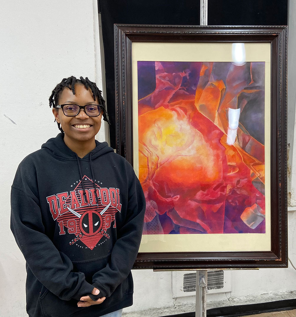 Moriah Roland poses with her artwork