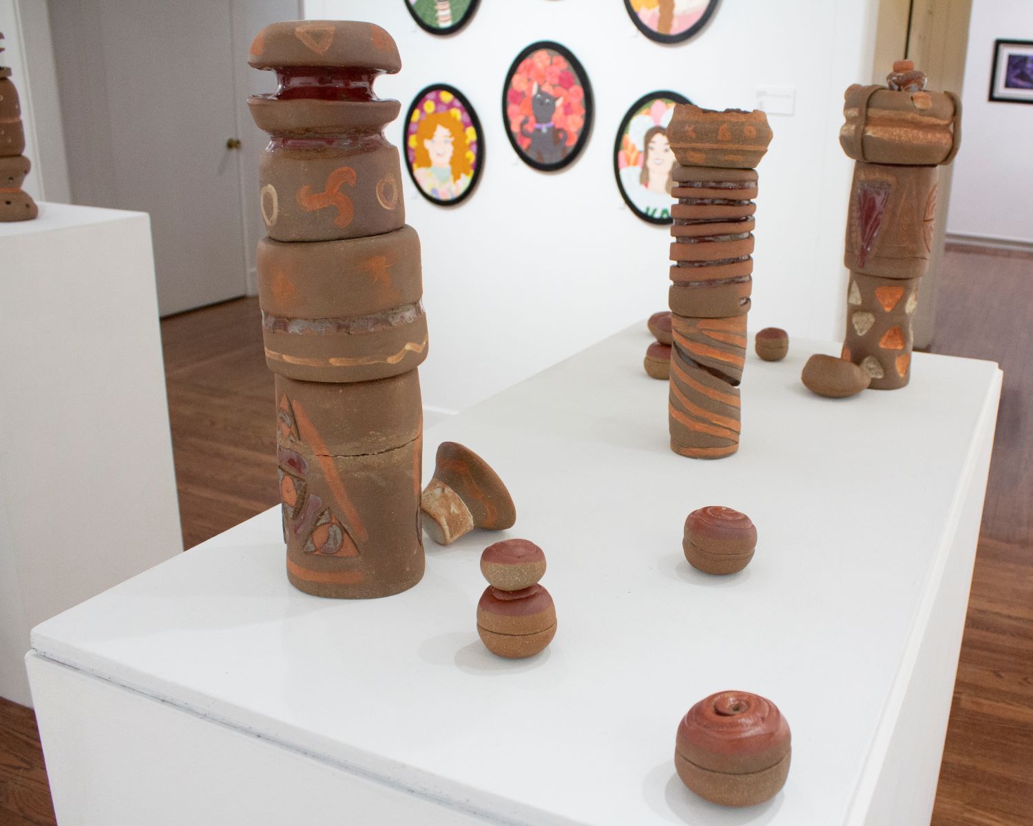 Image of three tall ceramic pieces with small spheric ceramic pieces around.