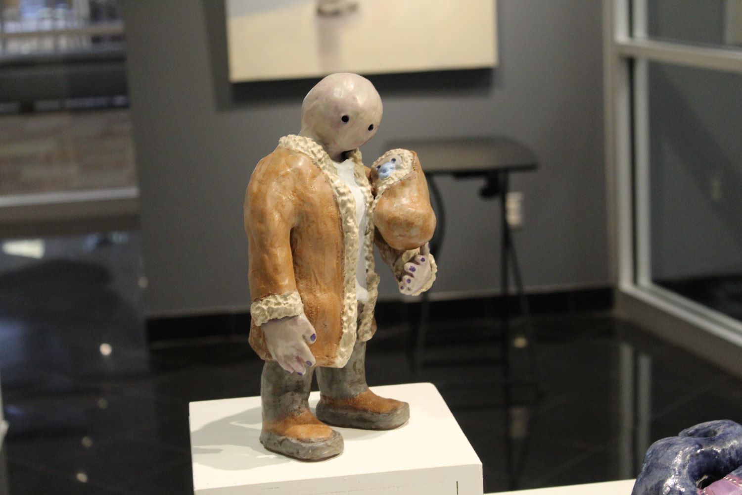 ceramic piece of a man standing up while holding something in his hands